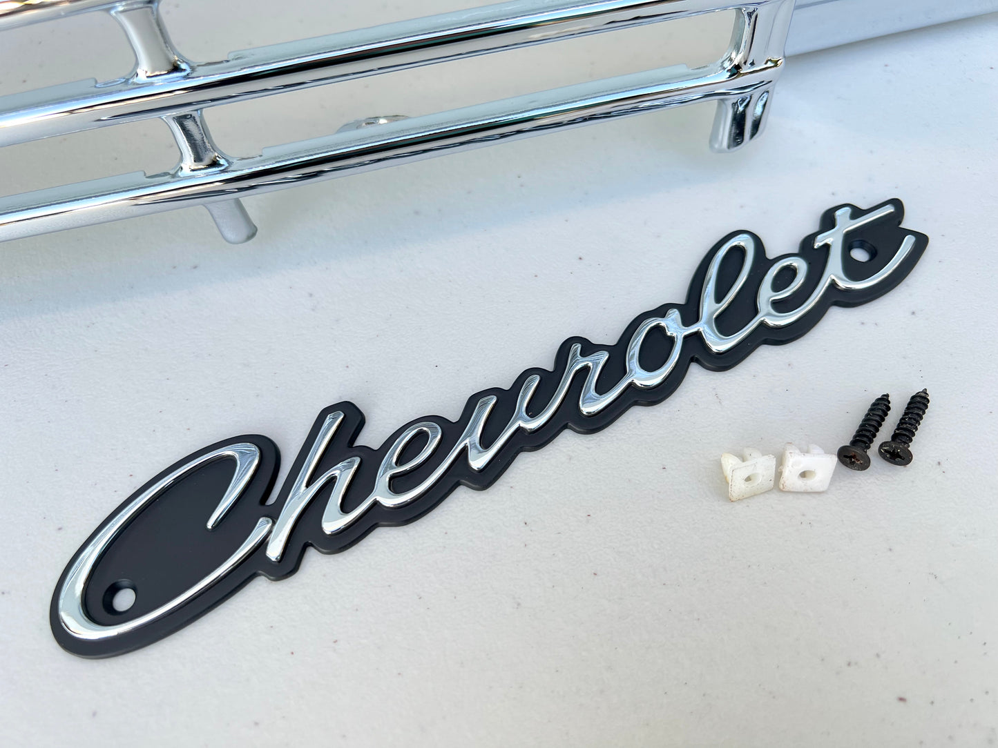 1964 CHEVY IMPALA / FULL SIZE FRONT GRILLE EMBLEM CHEVROLET SCRIPT W/ HARDWARE (NEW)